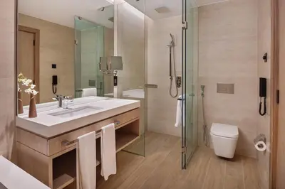a bathroom with a sink and a toilet and a shower at JA Lake View Hotel, Dubai in Dubai