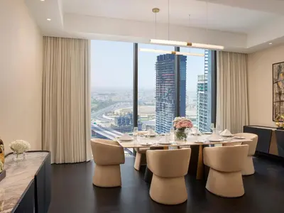 a dining room with a table and chairs and a large window at Anantara Downtown Dubai in Dubai