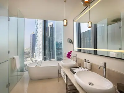 a bathroom with two sinks and a large window at Anantara Downtown Dubai in Dubai