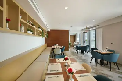 a dining room with tables and chairs and tablesktop at Millennium Executive Apartments Mont Rose in Dubai