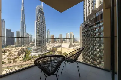 two chairs on a balcony with a view of a city at Maison Privee - Elevated Living with Spectacular Burj Khalifa Views in Dubai