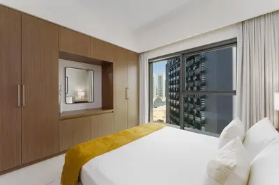 a bedroom with a large bed and a window at Maison Privee - Elevated Living with Spectacular Burj Khalifa Views in Dubai