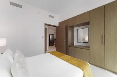 a bedroom with a white bed and a mirror at Maison Privee - Elevated Living with Spectacular Burj Khalifa Views in Dubai