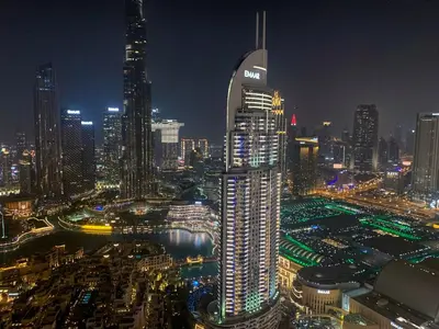 a lit up city at night with a tall building at Maison Privee - Elevated Living with Spectacular Burj Khalifa Views in Dubai