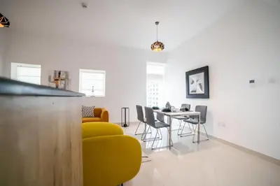 a living room with a yellow chair and a table at Continental Tower, Dubai Marina - Luton Vacation Homes in Dubai