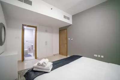 a bedroom with a large bed with towels on it at Continental Tower, Dubai Marina - Luton Vacation Homes in Dubai