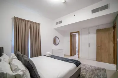 a bedroom with a white bed and a large window at Continental Tower, Dubai Marina - Luton Vacation Homes in Dubai