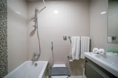 a bathroom with a tub and a toilet and a sink at Continental Tower, Dubai Marina - Luton Vacation Homes in Dubai