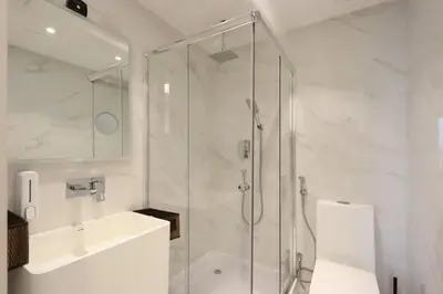 a bathroom with a shower and a toilet and a sink at Elite Duplex Penthouse Steps from Metro & Marina in Dubai