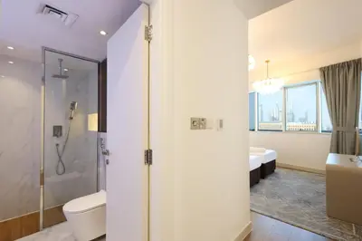 a bathroom with a shower and a toilet and a sink at Elite Duplex Penthouse Steps from Metro & Marina in Dubai