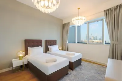 a bedroom with two beds and a large window at Elite Duplex Penthouse Steps from Metro & Marina in Dubai