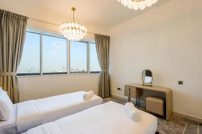 a hotel room with two beds and a desk at Elite Duplex Penthouse Steps from Metro & Marina in Dubai