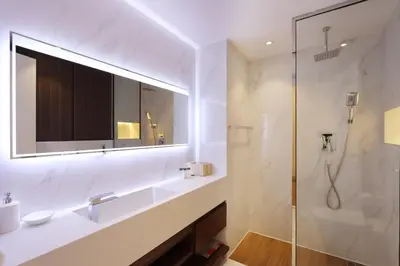a bathroom with a shower and a sink and a mirror at Elite Duplex Penthouse Steps from Metro & Marina in Dubai