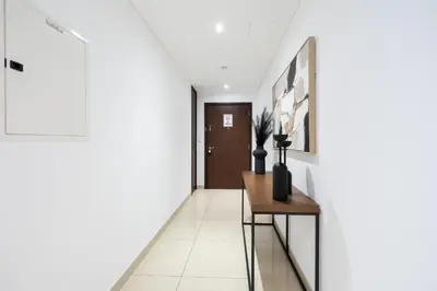 a hallway with a table and a door at Spectacular 2BR with Burj Khalifa and Fountain View in Dubai