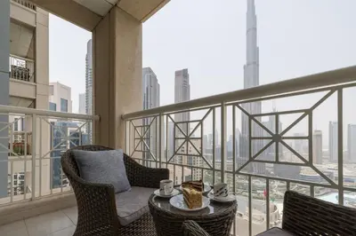 a balcony with chairs and a table on a building at Spectacular 2BR with Burj Khalifa and Fountain View in Dubai