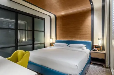 a bedroom with a large bed and a yellow chair at Andaz Family Suites by Hyatt- Palm Jumeirah in Dubai