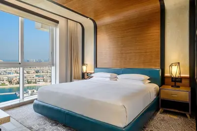 a bedroom with a large bed and a large window at Andaz Family Suites by Hyatt- Palm Jumeirah in Dubai