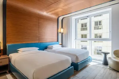 two beds in a room with a large window at Andaz Family Suites by Hyatt- Palm Jumeirah in Dubai