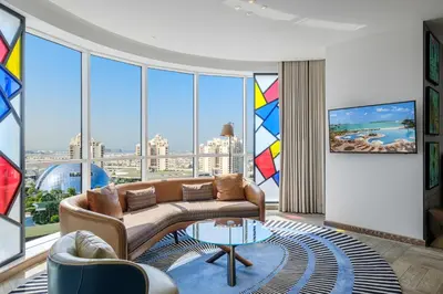 a living room with a couch and a large window at Andaz Family Suites by Hyatt- Palm Jumeirah in Dubai