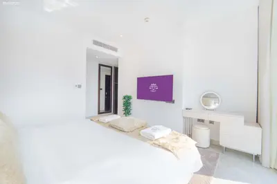 a white bedroom with a bed and a desk at JW Marriott Full Marina View, Luxury Suites by Gardenia with Direct Access to Marina Mall in Dubai
