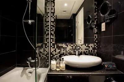 a bathroom with a sink and a shower and a tub at Staycae Bay's Edge in Dubai