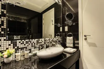 a black and white bathroom with a sink and a mirror at Staycae Bay's Edge in Dubai