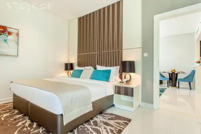 a hotel room with a bed and a table and a room at Staycae Bay's Edge in Dubai