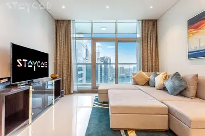 a living room with a couch and a flat screen tv at Staycae Bay's Edge in Dubai