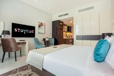 a bedroom with a large white bed and a desk at Staycae Bay's Edge in Dubai