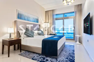 a bedroom with a large bed and a large window at Staycae Avanti in Dubai