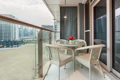 a balcony with a table and chairs with a view at Staycae Avanti in Dubai