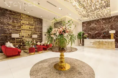 a lobby with a vase of flowers on a table at Staycae Avanti in Dubai