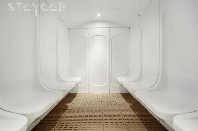 a hallway with two white benches and a tile floor at Staycae Avanti in Dubai