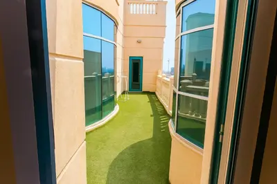 an empty balcony with green flooring in a building at Masters and Double Rooms For Girls ONLY in Marina, Dubai in Dubai