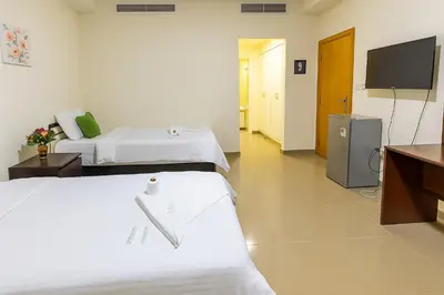 a hotel room with two beds and a flat screen tv at Masters and Double Rooms For Girls ONLY in Marina, Dubai in Dubai