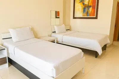 two beds in a room with white sheets at Masters and Double Rooms For Girls ONLY in Marina, Dubai in Dubai