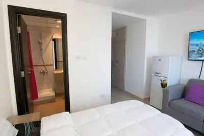 a bedroom with a white bed and a blue couch at La Rivera Rooms for Ladies in Dubai
