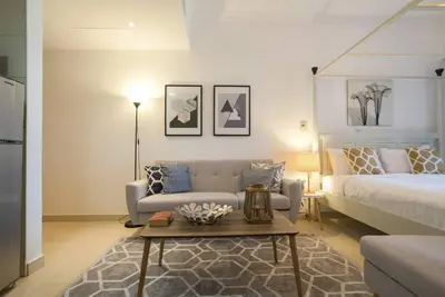 a bedroom with a bed and a couch and a table at GuestReady - Modern Studio | Stunning Marina Views in Dubai