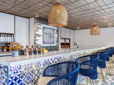 a bar with blue and white tiles and blue chairs at Novotel Dubai Al Barsha in Dubai