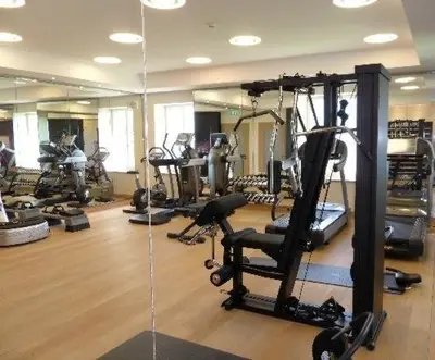a gym with several tread machines and a mirror at Al Jazeera Hotel Apartments LLC in Dubai