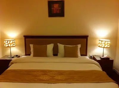 a bedroom with a large bed with two lamps at Al Jazeera Hotel Apartments LLC in Dubai
