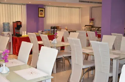 a dining room with white tables and white chairs at Al Jazeera Hotel Apartments LLC in Dubai