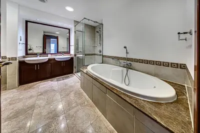 a bathroom with two sinks and a bath tub at Nice 2BD apartment in the Palm Jumeirah in Dubai