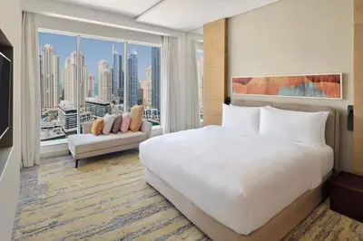 a bedroom with a large white bed and a large window at Crowne Plaza Dubai Marina by IHG in Dubai