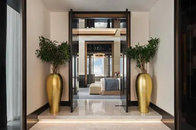 a hallway with two gold vases and a mirror at Taj Jumeirah Lakes Towers in Dubai