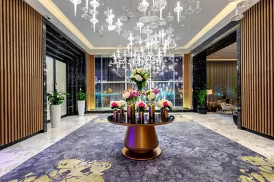 a lobby with a table with flowers and a chandelier at Taj Jumeirah Lakes Towers in Dubai