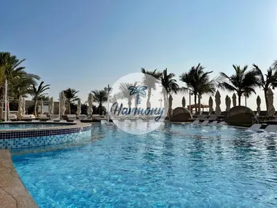 a pool at a resort with a sign that reads holiday at Harmony Vacation Homes - BALQIS Residence in Dubai