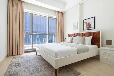 a white bedroom with a large bed and large windows at Frank Porter - Mon Reve in Dubai