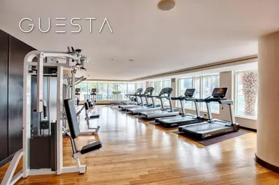 a gym with a row of treadmills and ellipticals at Al Majara by EMAAR, Dubai Marina in Dubai