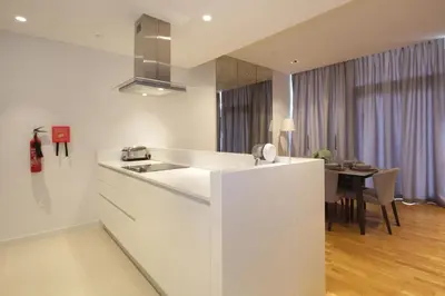 a white kitchen with a sink and a table at New Arabian Luxury 2 Bedroom In Blue Water in Dubai